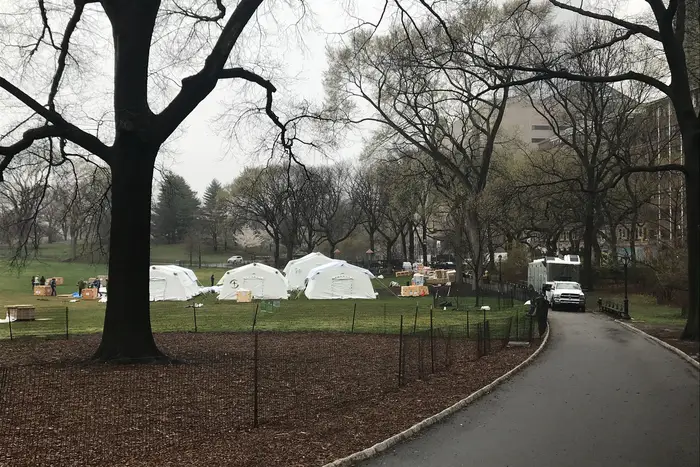 Workers assemble emergency field hospital tents in Central Park during the coronavirus pandemic.